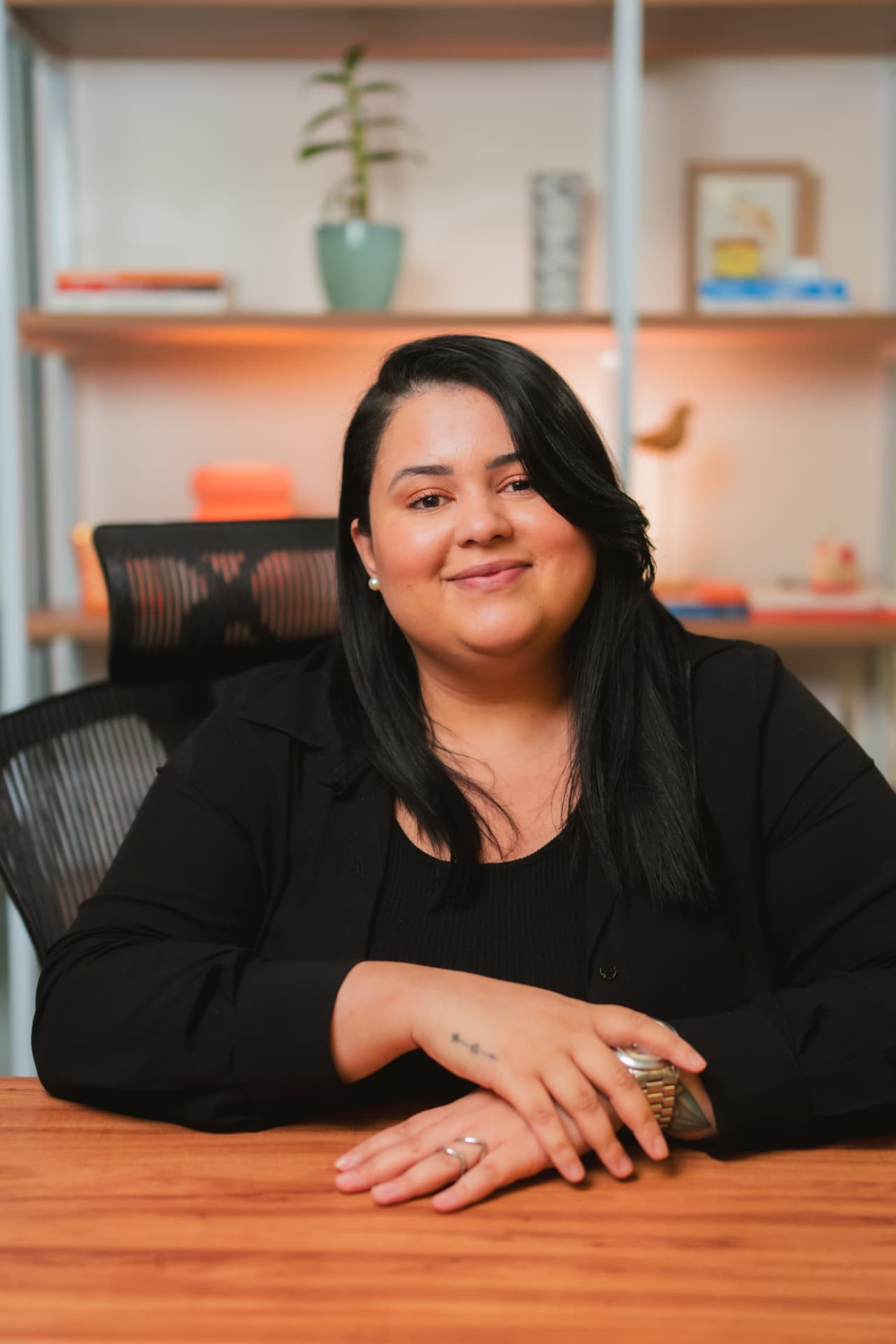 Ariane Lima sentada à mesa do escritório